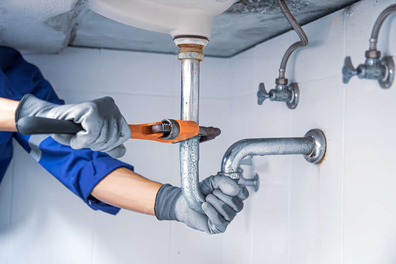 Plumber working under a sink